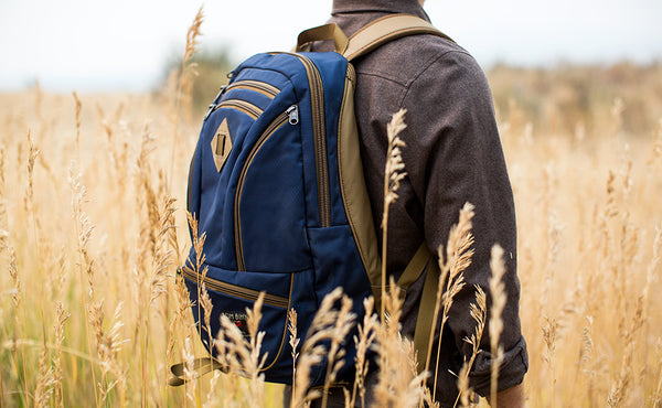 A person hiking in a prairie wearing a Guide's Edition Synapse 25.